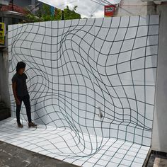 a man standing in front of a white wall with black lines on it and an umbrella