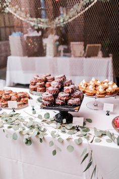 a table topped with lots of pastries on top of a white cloth covered table