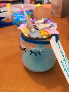 a glass jar filled with blue liquid and a unicorn face on it's lid