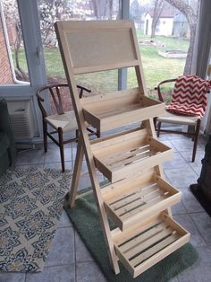 a wooden step stool sitting on top of a tile floor next to a chair and window