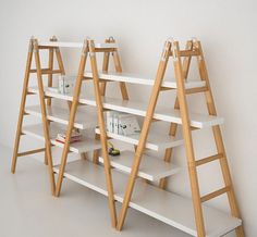 three wooden ladders are standing next to each other in front of a white wall