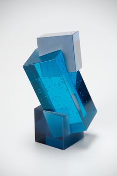 a blue glass sculpture sitting on top of a white table