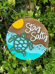 a wooden sign that says stay salty with a sea turtle