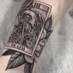 a black and white tattoo on the arm of a person with a skull in it