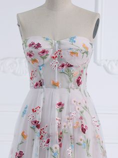 a dress on a mannequin with flowers and butterflies all over the bustle