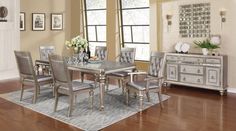 a dining room table with chairs and a rug on the floor