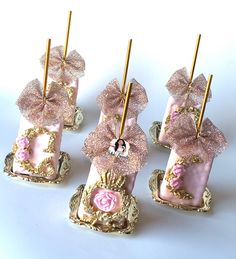 four pink and gold decorated candlesticks sitting on top of each other