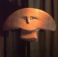 a stone sculpture with a face on it's head