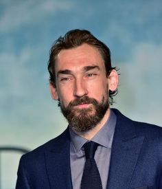 a man with a beard wearing a suit and tie