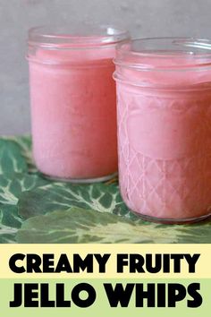 two jars filled with fruity jello sitting on top of a green table cloth