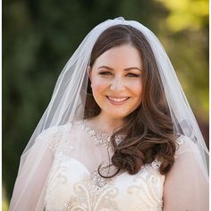 a woman in a wedding dress smiles at the camera