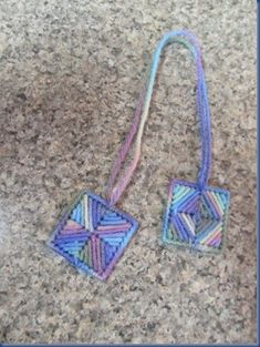 two pieces of colorful string on top of a granite counter next to a cell phone