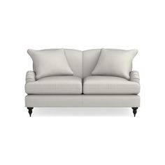 a white couch with two pillows on it's back and one arm facing the camera