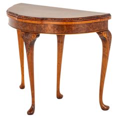 an oval shaped table with wooden legs and carvings on the top, against a white background