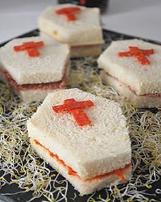 four small sandwiches with red crosses on them