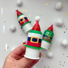 someone is holding two small christmas hats on top of each other in front of confetti sprinkles