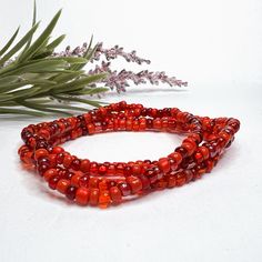 This red glass beaded necklace is made of size 6/0 Czech glass seed beads in a variety of red tones. It can be made as a bracelet, anklet, or necklace - or order it in a stretch option that's long enough for wrapping and you can get a variety of styles from this piece! Note that stretch options will often be finished with a metal bead to secure the knot - the bead will be in the accent metal of your choice if the other beads do not have a sufficient hole size to secure and hide a knot properly. Handmade Red Czech Glass Beaded Bracelets, Traditional Red Beaded Bracelets For The Beach, Red Czech Glass Beaded Bracelets With Colorful Beads, Red Polished Beaded Bracelets For Festival, Red Beaded Bracelet With 108 Beads For Festival, Adjustable Red Czech Glass Beads, Red Czech Glass Beaded Bracelets, Red Bohemian Beaded Bracelet, Red Polished Beads Necklace For Beach