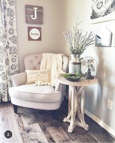 a white chair sitting next to a table with flowers on it in a living room