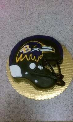 a cake shaped like a football helmet on top of a table with the baltimore ravens logo