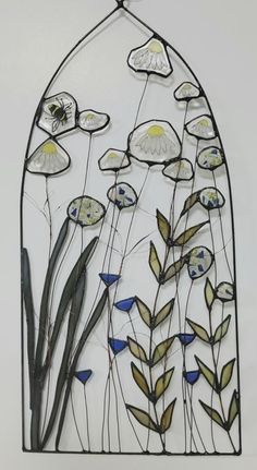 a stained glass window with flowers and grass