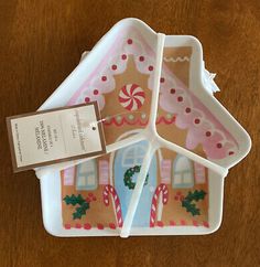 a small house shaped plate with candy canes on the front and side pieces cut out