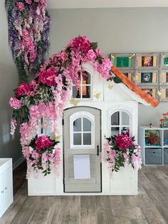 a doll house with pink flowers on the outside