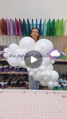 a woman standing in front of some balloons