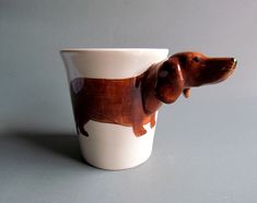 a brown dog figurine sitting on top of a white cup