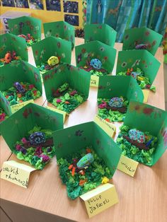 a table topped with lots of green boxes filled with different types of plants and animals