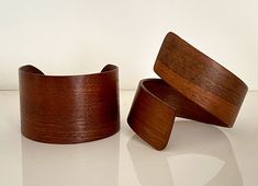 two wooden bracelets sitting next to each other