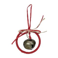 an ornament hanging from a red string with a bell on it's end