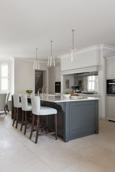 a large kitchen with an island and bar stools