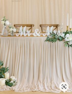 the table is set up with candles and flowers for mr and mrs signs on it