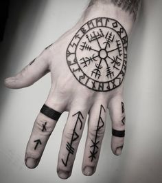 a person's hand with some tattoos on it