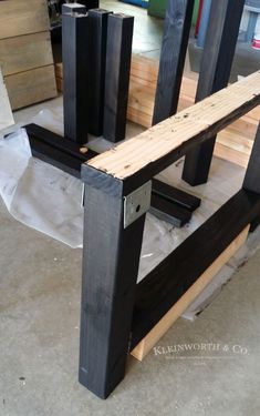 a wooden bench sitting on top of a floor next to other wood planks and plywood