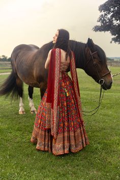 a woman standing next to a brown horse