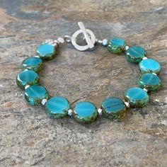 These pretty turquoise colored disk shaped beads are Czech glass. Each bead is separated with a small sterling silver nugget. The bracelet is finished with a sterling silver Hill Tribe toggle clasp and charm.Choose you size from the drop down menu. (7.5 inch is standard) Listing for complementary earrings: https://www.etsy.com/listing/513747439/aqua-and-silver-earrings-turquoise-czech?ref=shop_home_active_4Your jewelry will arrive in a cotton lined kraft box within a padded postal envelope. I us Handmade Gift Tags, Coral Bracelet, Labradorite Bracelet, Earrings Turquoise, Glass Bracelet, Cluster Earrings, Czech Beads, Toggle Clasp, Turquoise Color