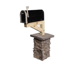 a black mailbox sitting on top of a stack of bricks