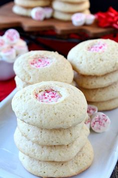 white cookies stacked on top of each other with pink and red candies in the middle