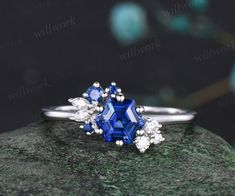 ***This ring showcases a gorgeous cluster design that not only accentuates the center stone but also gives you a heartwarming feeling of being surrounded by love. The addition of three blue sapphire embellishments on the side makes the ring even more distinctive.***- Metal: Solid gold(10K/14K/18K white/yellow/rose gold),925 sterling silver,platinum available- Main Stone: 6x6mm hexagon cut lab blue sapphire- Accent Stone: lab blue sapphire and moissanites or natural diamonds- Can be personalized: Luxury Cluster Ring Gift, Fine Jewelry Cluster Ring For Proposal, Fine Jewelry Sapphire Cluster Ring As Gift, Asscher Cut Cluster Ring Fine Jewelry Gift, Asscher Cut Cluster Ring Gift, Fine Jewelry Asscher Cut Cluster Ring Gift, Gift Sapphire Cluster Ring With Rose Cut Diamonds, Elegant Cluster Sapphire Ring As Gift, Elegant Cluster Sapphire Ring For Gift