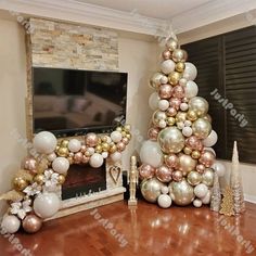 a christmas tree made out of balloons in front of a fireplace with a television on