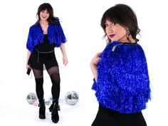 "Once upon a time, in a magical world of tinsel and fringe, there was a cobalt blue jacket that stood out from the rest. This wasn't your average jacket - it was a masterpiece of shimmering tinsel and swaying fringe that could make anyone feel like the king or queen. As you strut down the street in this cobalt blue fringe jacket, heads will turn, jaws will drop, and compliments will flow like a river. And who wouldn't want that kind of power? This jacket is not for the faint of heart - it's for Blue Outerwear For Costume Party In Fall, Party Blue Sequined Outerwear, Blue Sequined Outerwear For Party, Festive Blue Outerwear For Fall, Tinsel Jacket, King Or Queen, Make Dreams Come True, Fringe Jacket, Magical World