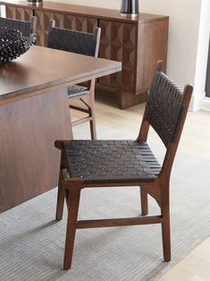 a wooden dining table with two chairs and a bowl on top of the table in front of it