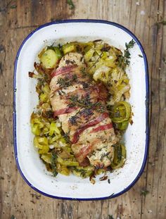 meat and vegetables in a casserole dish on a wooden table