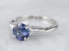 This vintage sapphire and diamond engagement ring is the epitome of a classic! This intense blue sapphire is a perfect, rich color, the benchmark for a fine sapphire. The crisp blue hue is filled with glitter and it has phenomenal light refraction, depth of color, and sparkle on the finger! We've set this in a tasteful platinum mounting featuring baguette diamonds on either side, equal in quality and sparkle to this lovely center sapphire. The ring was originally designed as an engagement piece, Sapphire And Diamond Engagement Ring, Light Refraction, Platinum Engagement Ring, Vintage Sapphire, Baguette Diamonds, Platinum Engagement Rings, Baguette Diamond, Anniversary Ring, Blue Hues