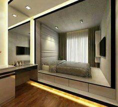 a bedroom with a large mirror on the wall next to a sink and bed in it