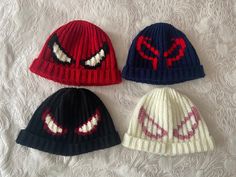 three knitted hats with spiderman faces on them