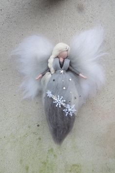 an angel doll hanging from the ceiling with snowflakes on it's wings