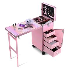 a pink desk with drawers and makeup on it