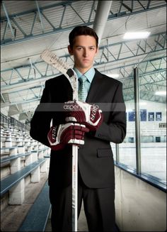 a man in a suit holding a hockey stick